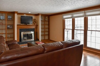Family room with a fireplace framed with shelving.