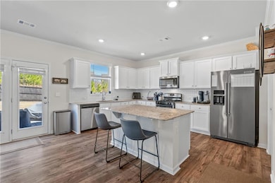 Kitchen with a sink, visible vents, appliances wit