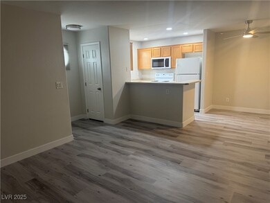 Kitchen with white appliances, a peninsula, wood f
