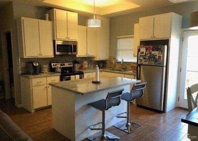 Kitchen with stainless steel appliances, dark wood-type flooring, healthy amount of natural light, and tasteful backsplash