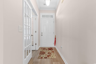 Doorway with ornamental molding, baseboards, and l