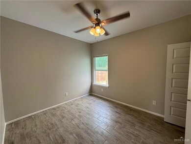 Spare room with ceiling fan, dark wood-style floors, and baseboards