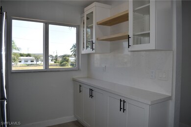 Kitchen featuring open shelves, light countertops,
