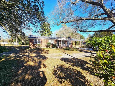 Rear view of property with brick siding and covered porch