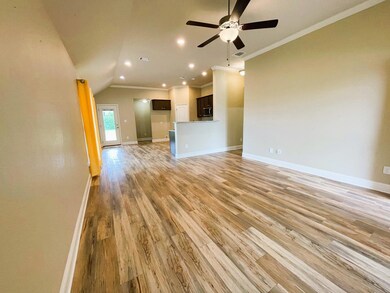 Unfurnished living room with light hardwood / wood-style flooring, ceiling fan, and crown molding