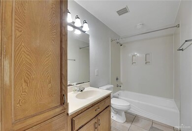 Full bathroom featuring shower / tub combination, tile flooring, large vanity, and toilet