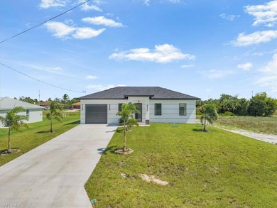View of front of property featuring concrete driveway, a front lawn, a garage, and stucco siding