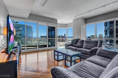Living room with a view of skyline, rail lighting, and wood finished floors
