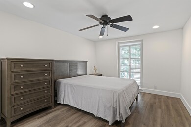 Bedroom with dark wood-type flooring, recessed li
