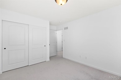 Unfurnished bedroom with light carpet and a closet