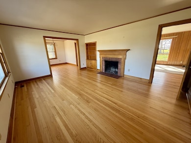 The living room has gleaming hardwood floors, built-in bookcase and wood-burning fireplace.