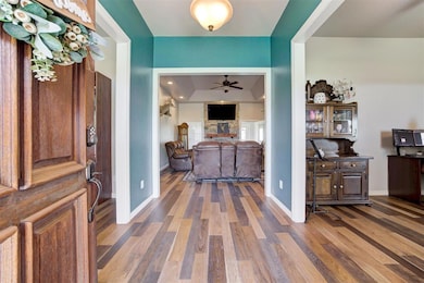 Entryway with a ceiling fan, wood finished floors, and baseboards