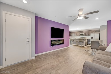 Living room with a ceiling fan, recessed lighting,