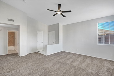Carpeted spare room featuring ceiling fan and base