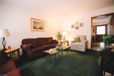 Living room is open and spacious with large window letting in natural light.