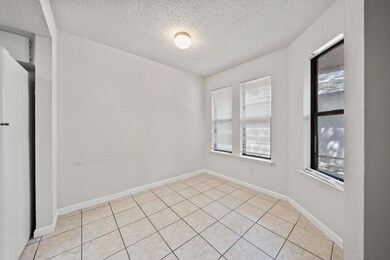 Spare room with baseboards, a textured ceiling, a