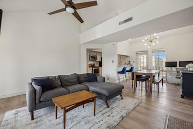 Living area featuring visible vents, high vaulted 