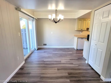Unfurnished dining area with a chandelier and dark wood-style flooring