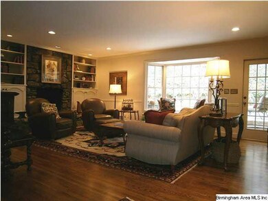 Den has bookcases on both sides of the stone firep
