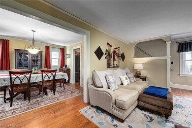 Living room with ornamental molding and wood-type flooring