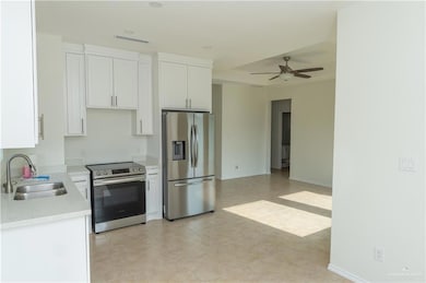Kitchen with a sink, white cabinets, and stainless steel appliances