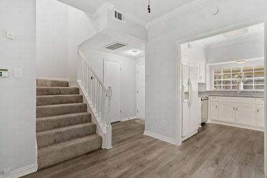 Kitchen with white appliances, crown molding, dark