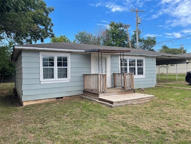 Rear view of property with a lawn, a carport, and 