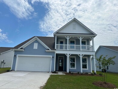 View of front facade with a balcony and a front ya