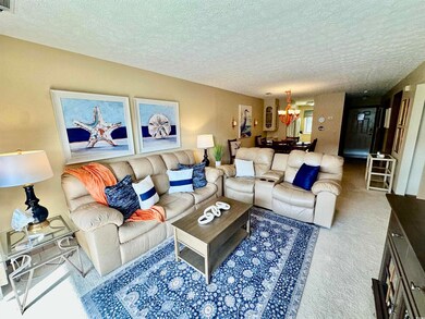 Carpeted living room featuring a textured ceiling 