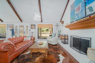 Living area featuring a fireplace, wood finished floors, and crown molding