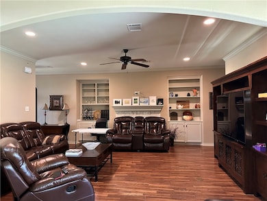 Living area featuring ceiling fan, crown molding,