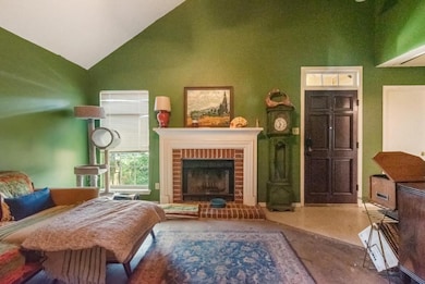 Living room with high vaulted ceiling and a brick fireplace