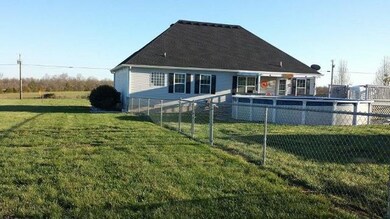 BACKYARD FEATURES A ABOVE GROUND 24FT SWIMMING POOL WITH A CHAIN LINK FENCE AROUND IT, LARGE STORAGE SHED AND LOTS OF CONCRETE CURBING AROUND THE LANDSCAPING.
