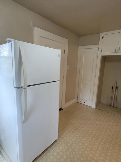 Kitchen with refrigerator, light floors, and whit