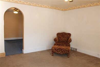 Living room has neutral carpeting and is move in r