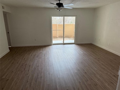 Empty room with a textured ceiling, baseboards, da