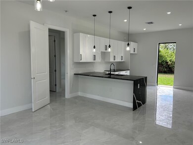 Kitchen featuring dark countertops, baseboards, li