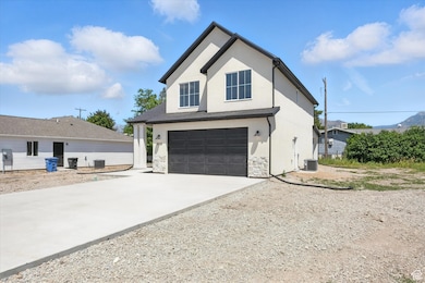 View of property exterior featuring driveway, stucco siding, an attached garage, and stone siding