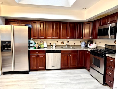 Kitchen featuring stainless steel appliances, tasteful backsplash, and light wood-type flooring