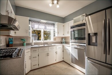 White cabinetry with newer stainless appliances