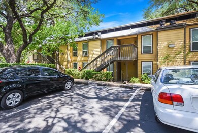 View of property with uncovered parking and stairs