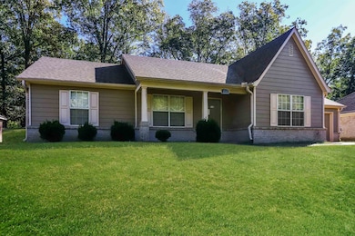 View of front facade featuring a front yard, brick siding, and roof with shingles