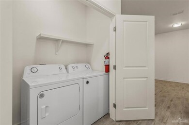Laundry area featuring washing machine and clothes dryer and light wood-style flooring