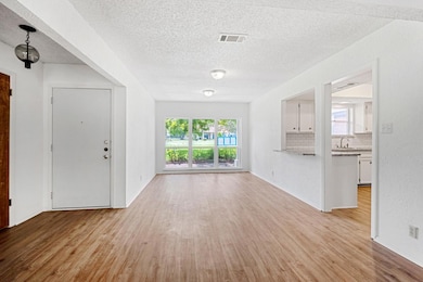 Unfurnished living room with light wood-style flooring and a textured ceiling
