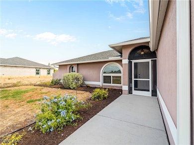 Doorway to property featuring a shingled roof and