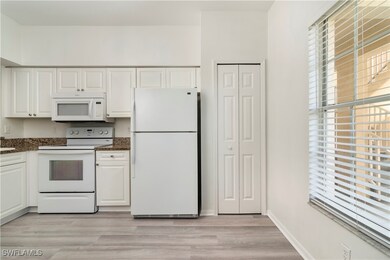 Kitchen featuring white cabinets, white appliances
