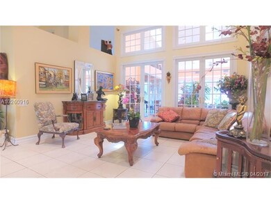 Formal living room has tall french doors and upper
