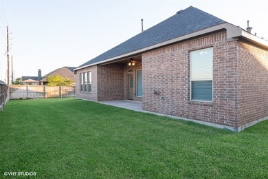 View of the backyard and covered back patio! Notice the FULL BRICK exterior!