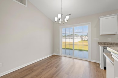 Unfurnished dining area with light wood-type flooring, a chandelier, and vaulted ceiling