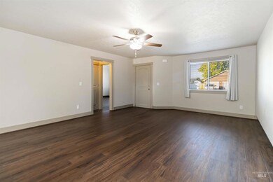 Empty room with dark wood-type flooring and a ceiling fan